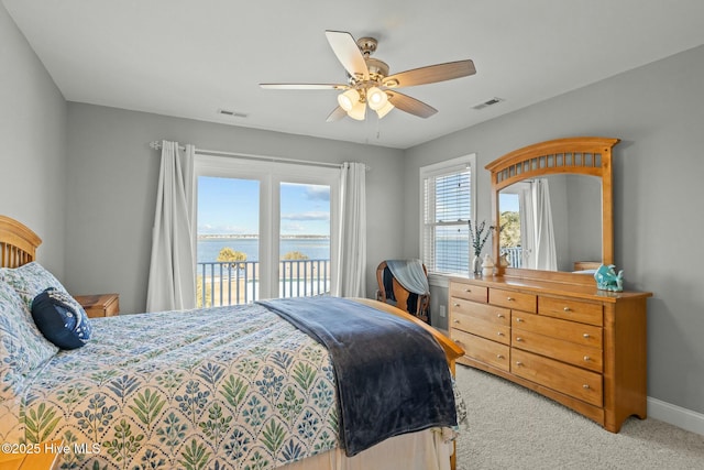 carpeted bedroom featuring ceiling fan, a water view, and access to outside