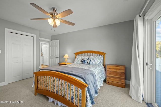 bedroom with ceiling fan, light colored carpet, and a closet