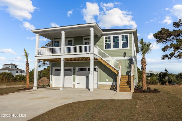 raised beach house featuring a porch and a garage