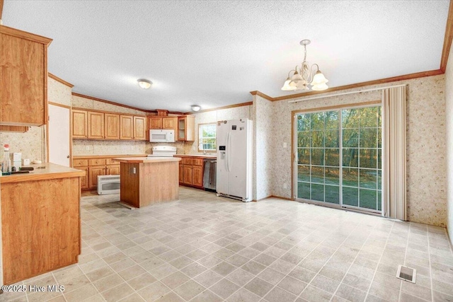 kitchen with white appliances, crown molding, pendant lighting, and a center island