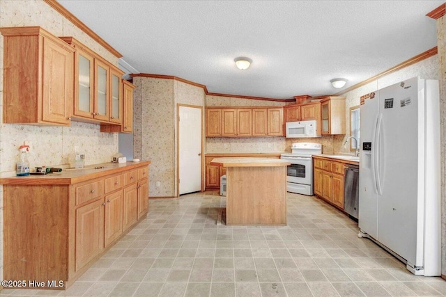 kitchen featuring white appliances, a center island, crown molding, a textured ceiling, and sink