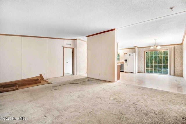 unfurnished room featuring a textured ceiling, crown molding, an inviting chandelier, and light carpet