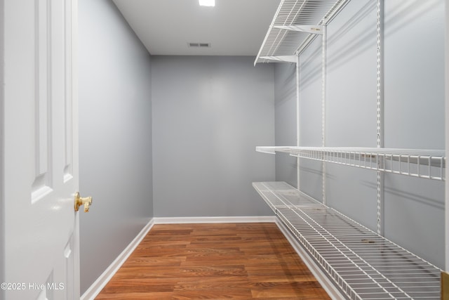 walk in closet with hardwood / wood-style floors