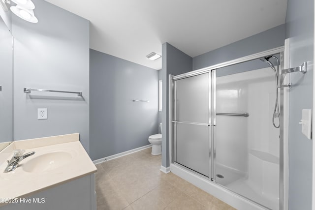 bathroom featuring vanity, tile patterned floors, a shower with door, and toilet