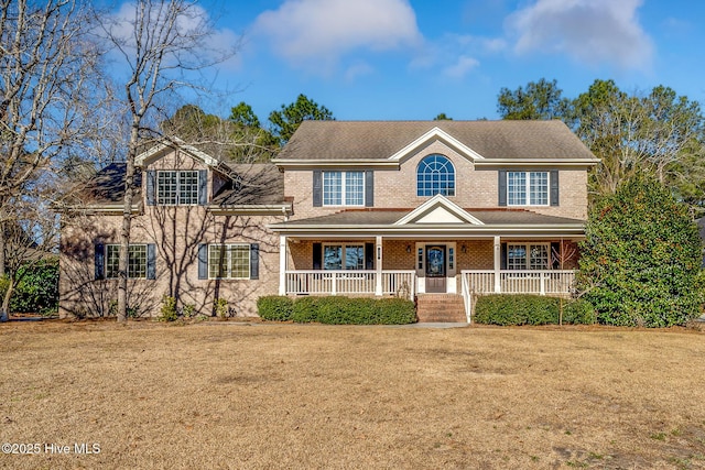 view of front of house featuring covered porch and a front lawn