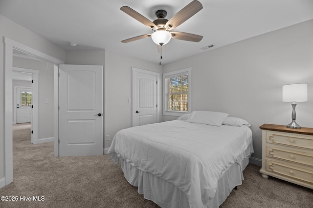 bedroom featuring multiple windows, light carpet, and ceiling fan