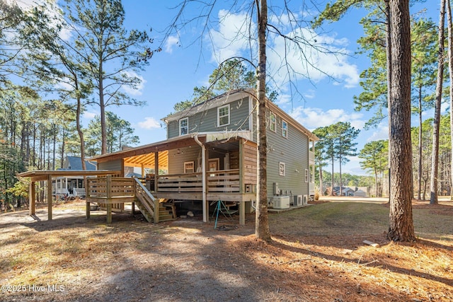 rear view of property featuring a wooden deck and central AC unit