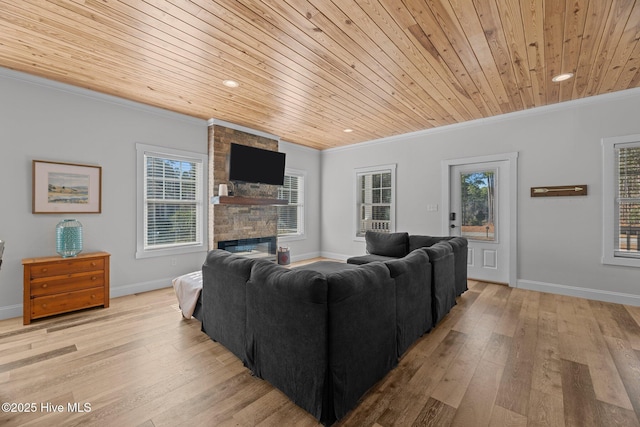 living room with crown molding, wood ceiling, a fireplace, and light hardwood / wood-style flooring