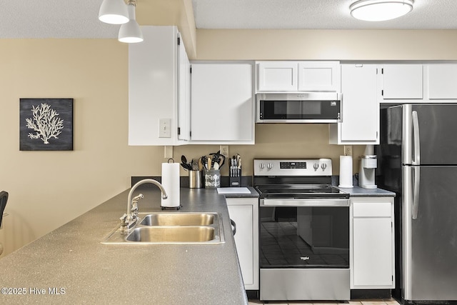 kitchen with pendant lighting, sink, white cabinetry, appliances with stainless steel finishes, and a textured ceiling