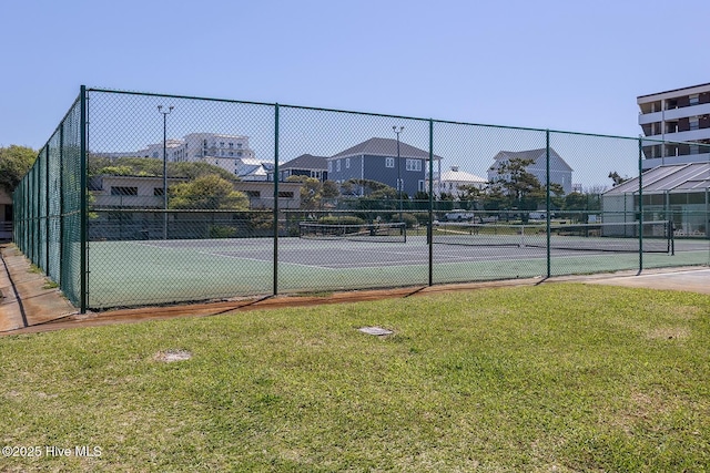 view of tennis court featuring a lawn