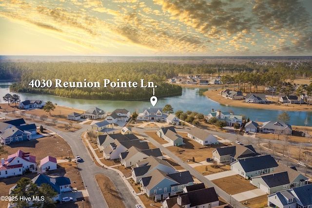 aerial view at dusk featuring a water view