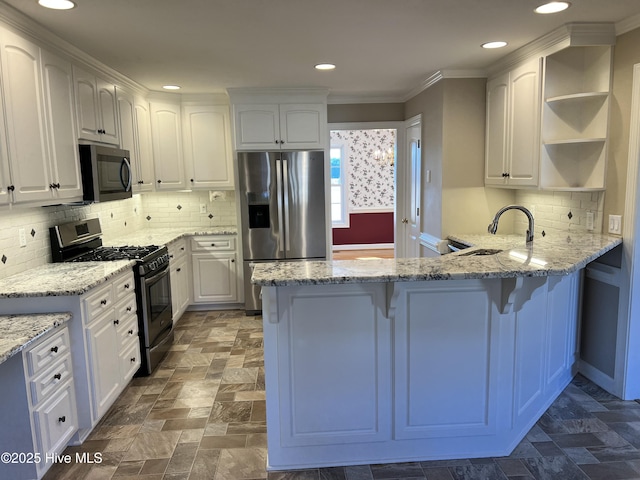 kitchen with stainless steel appliances, white cabinets, light stone counters, and sink