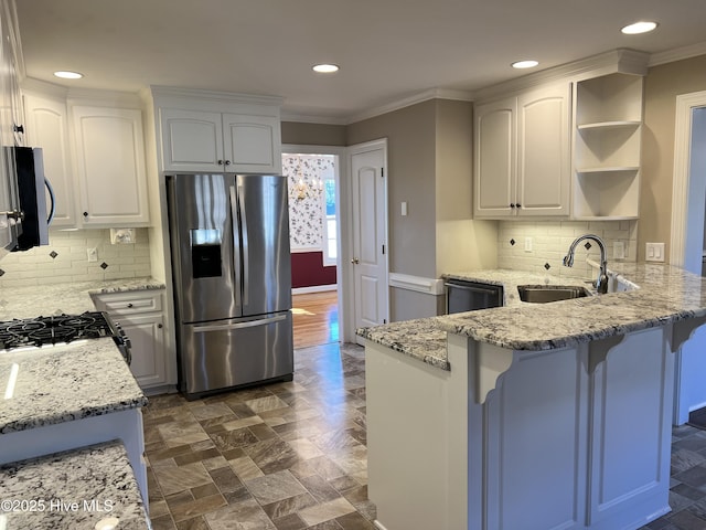 kitchen featuring white cabinets, appliances with stainless steel finishes, sink, and light stone counters