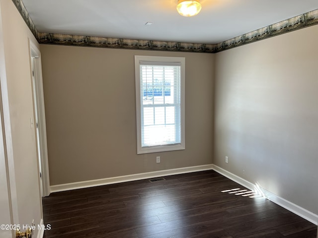 unfurnished room with dark wood-type flooring