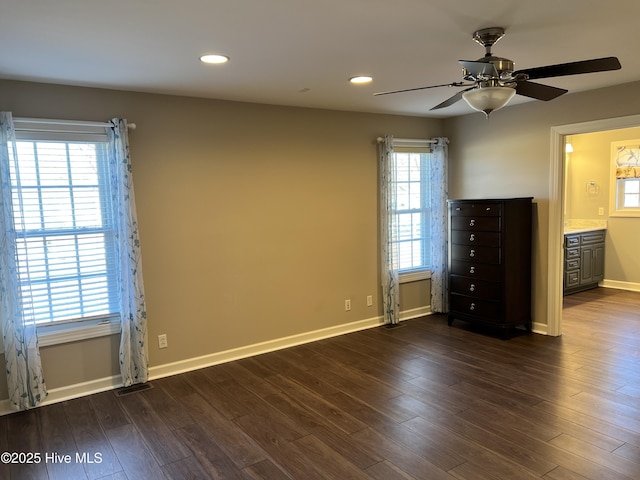 interior space featuring ensuite bath, dark wood-type flooring, and ceiling fan