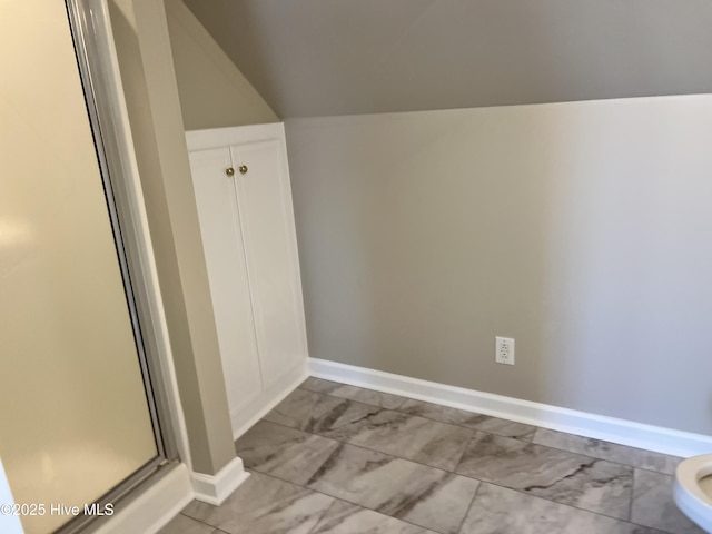 interior space with an enclosed shower and vaulted ceiling