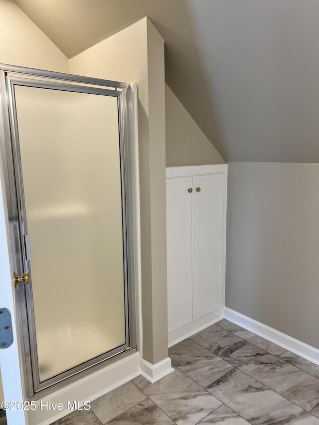 bathroom with vaulted ceiling and a shower with door