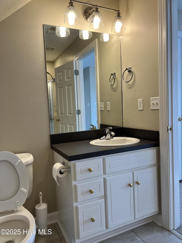 bathroom featuring toilet, vanity, and tile patterned floors