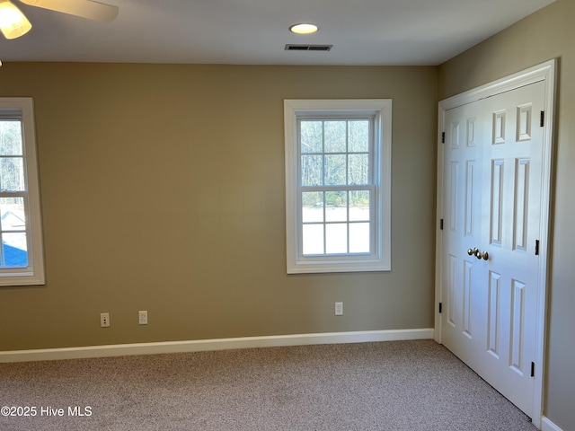 carpeted spare room featuring ceiling fan