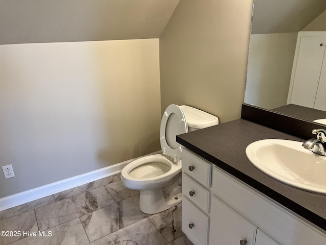 bathroom with toilet, vaulted ceiling, and vanity