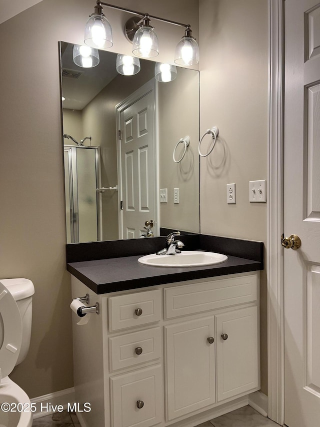 bathroom with a shower with shower door, toilet, vanity, and tile patterned flooring