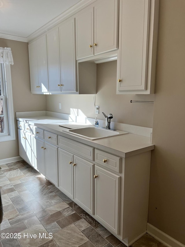 kitchen with sink, white cabinetry, and ornamental molding