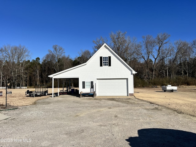 view of home's exterior with a garage, an outbuilding, and a carport