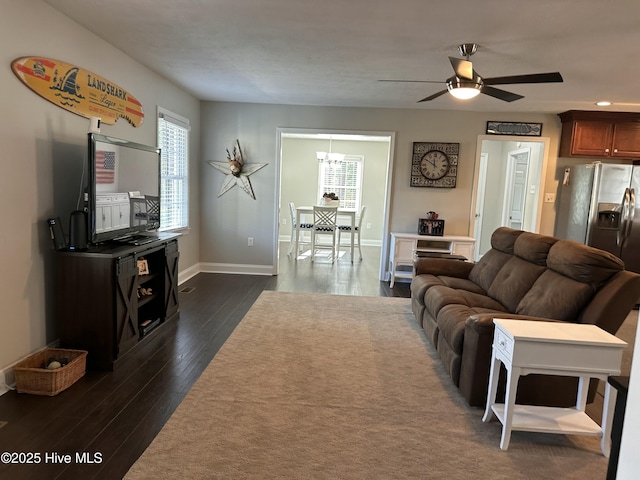 living room featuring dark wood-type flooring and ceiling fan