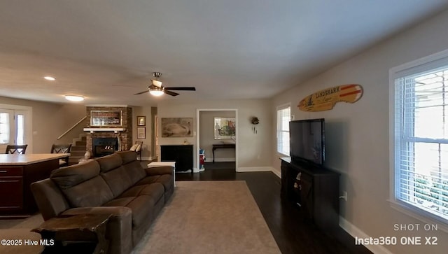 living room with ceiling fan, dark hardwood / wood-style flooring, and a fireplace