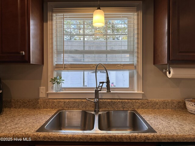 kitchen with sink, pendant lighting, and dark brown cabinets