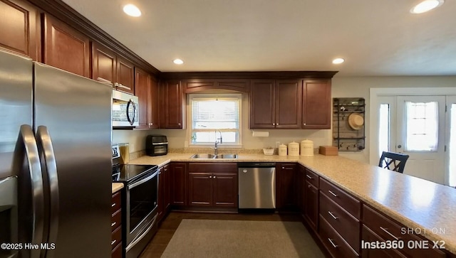 kitchen featuring stainless steel appliances, sink, and kitchen peninsula