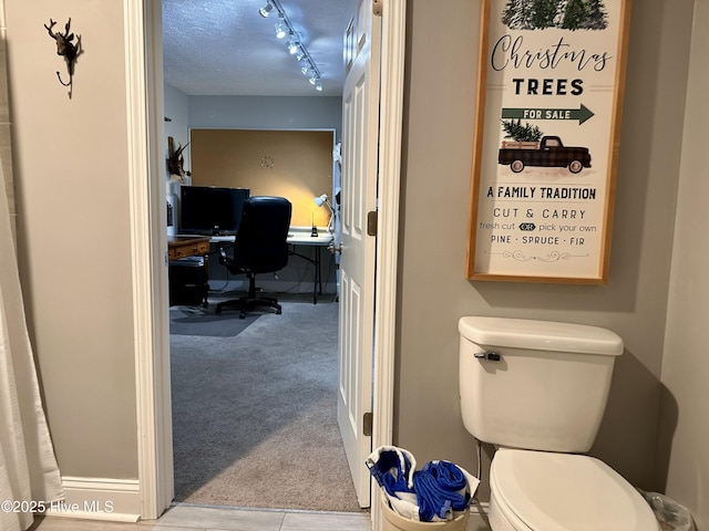 bathroom with a textured ceiling and toilet