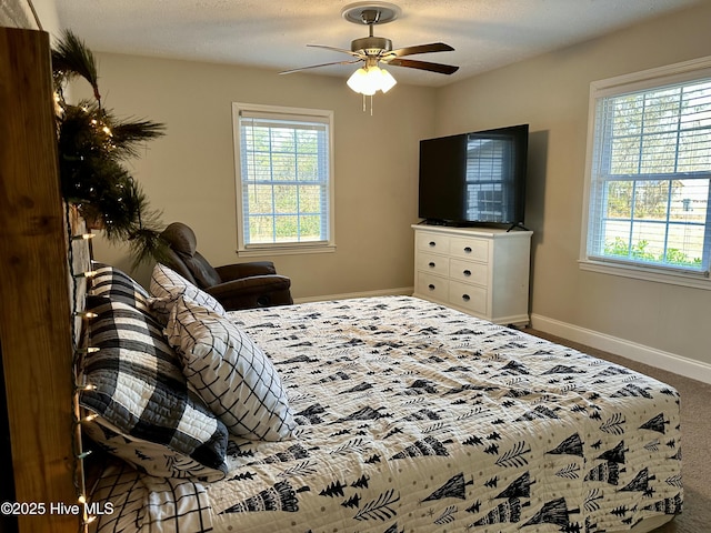 bedroom featuring ceiling fan, carpet floors, and a textured ceiling