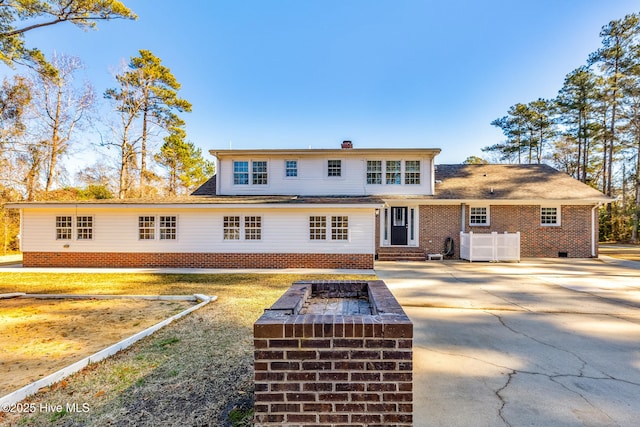 rear view of property with a fire pit