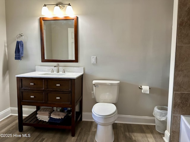 bathroom with hardwood / wood-style floors, toilet, and vanity