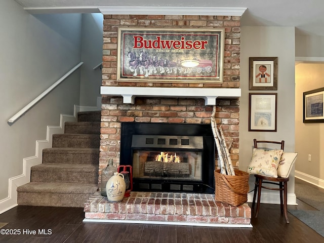 room details featuring a brick fireplace and wood-type flooring