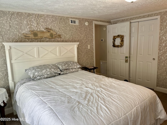 bedroom featuring carpet flooring, a closet, a textured ceiling, and crown molding