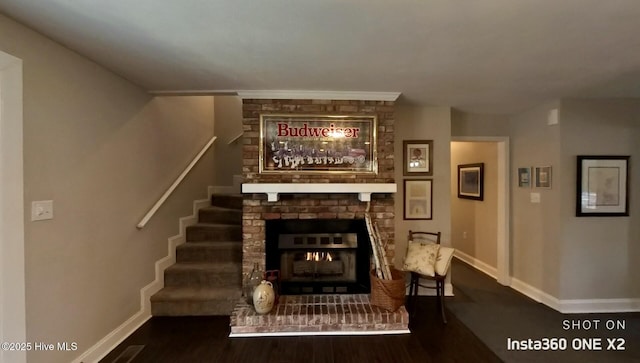 living room featuring a brick fireplace and hardwood / wood-style flooring