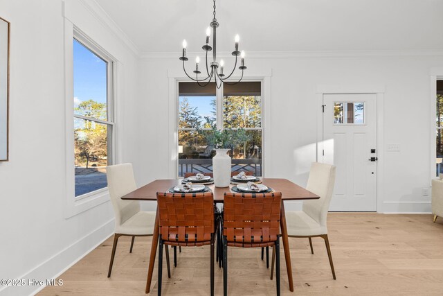 kitchen featuring light hardwood / wood-style flooring, decorative light fixtures, crown molding, and ceiling fan with notable chandelier