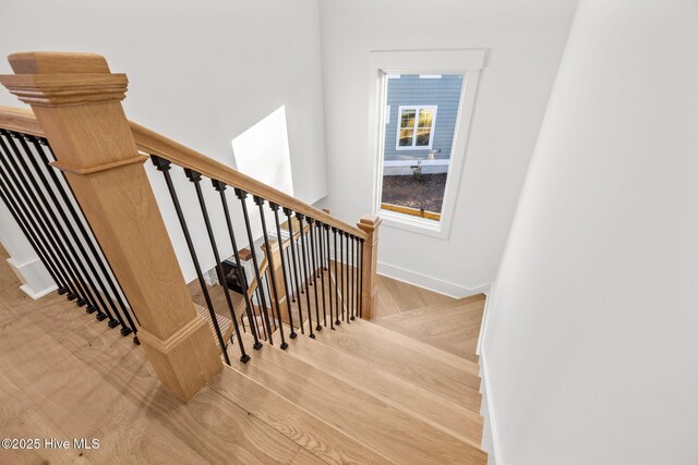 stairway featuring a fireplace, ornamental molding, and hardwood / wood-style flooring