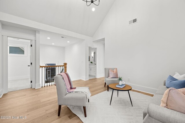 living room with light hardwood / wood-style flooring and vaulted ceiling