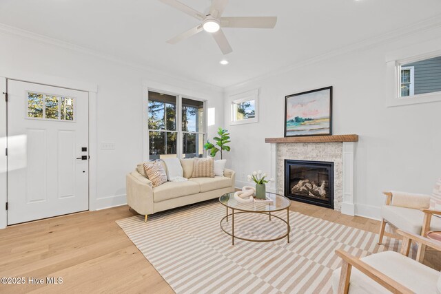 living room with ornamental molding, ceiling fan, light hardwood / wood-style flooring, and plenty of natural light