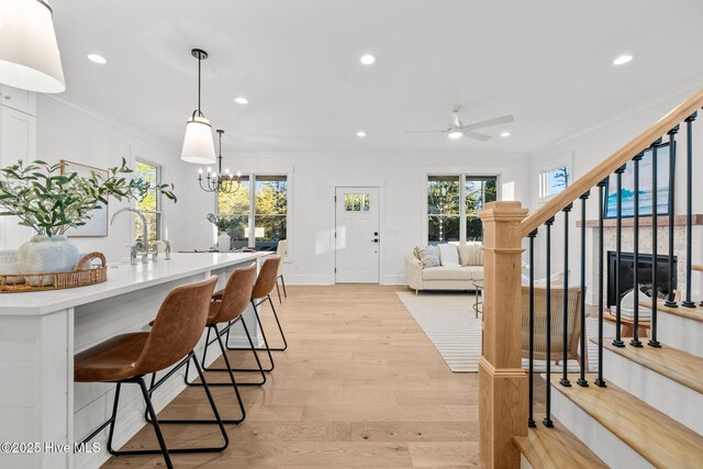 kitchen featuring a kitchen island with sink, stainless steel appliances, pendant lighting, decorative backsplash, and white cabinetry