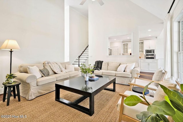 living room with ceiling fan, vaulted ceiling, and light hardwood / wood-style floors