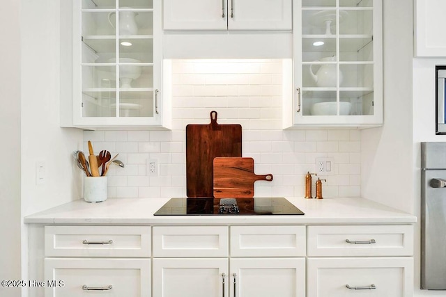 bar featuring white cabinetry, decorative backsplash, and black electric cooktop