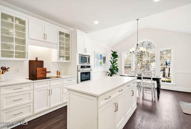 kitchen with white cabinetry, appliances with stainless steel finishes, tasteful backsplash, dark hardwood / wood-style flooring, and lofted ceiling