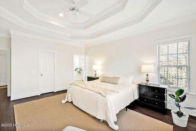 bedroom with ceiling fan, a tray ceiling, dark hardwood / wood-style floors, and crown molding