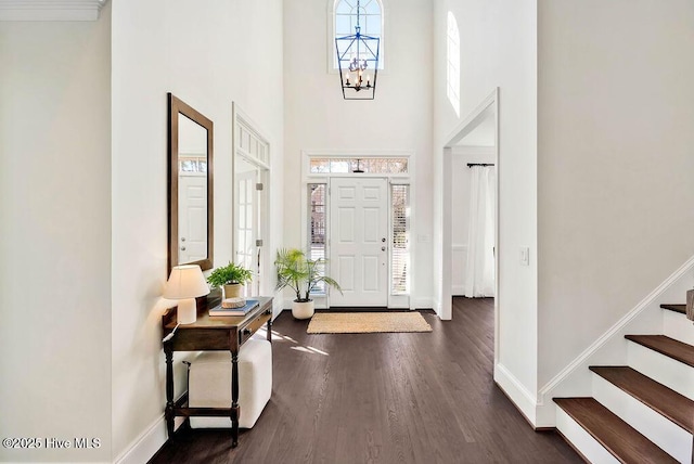 foyer featuring dark hardwood / wood-style floors, a chandelier, and a high ceiling