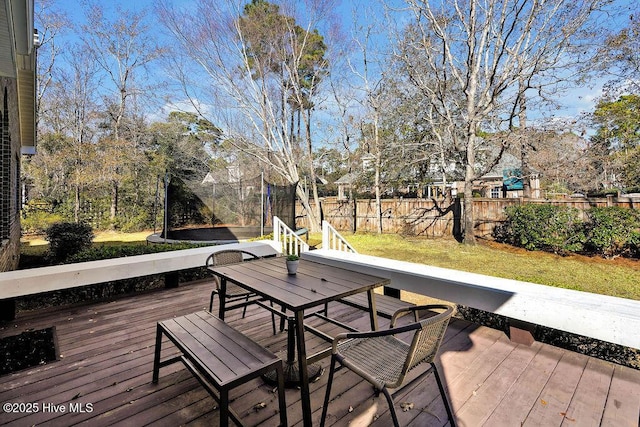 deck with a yard and a trampoline