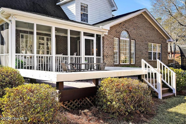 back of house featuring a wooden deck and a sunroom